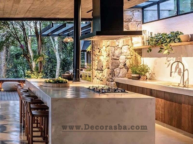 طراحی داخلی آشپزخانه جادار و شیک در ویلا با جزیره بزرگ و دیوار شیشه ای